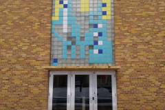 Building Exterior (south exterior of building with entrance door "F" and glass block mosaic overhead)